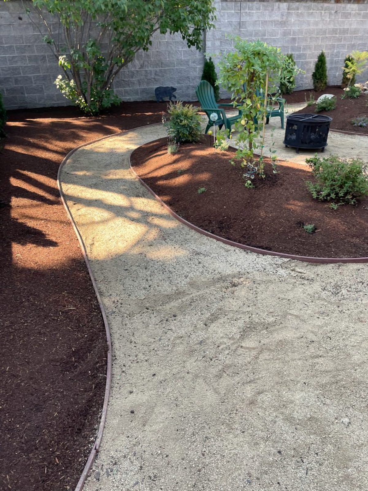 Renovated garden with a gravel path winding through layered planting beds, Medford Oregon
